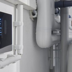 Das digitale Display eines Vaillant-Thermostats zeigt aktuelle Temperatur- und Luftfeuchtigkeitswerte in einem Heizungsraum.