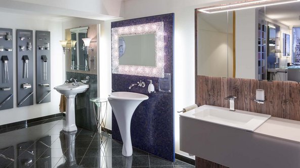 Im Badezimmer sind verschiedene Armaturen an der Wand montiert, während ein elegantes Waschbecken im Vordergrund steht.