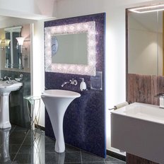 Im Badezimmer sind verschiedene Armaturen an der Wand montiert, während ein elegantes Waschbecken im Vordergrund steht.