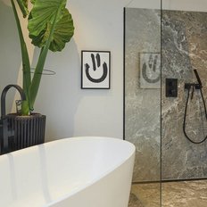 Ein modernes Badezimmer mit einer freistehenden Badewanne und einer eleganten Dusche aus Glas und Stein.