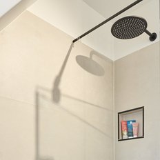 Eine moderne Dusche mit einer eleganten Regendusche und einem klaren Glasabtrennung, die einen minimalistischen Stil zeigt.