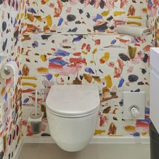 Ein modernes Badezimmer mit einer bunten, künstlerischen Wandgestaltung und einem eleganten, weißen WC.