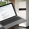 Der Laptop zeigt eine Umfrage zur Heizungswahl, während im Hintergrund eine stilvolle Küche zu sehen ist.