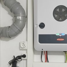 Der Fronius Symo Wechselrichter zeigt mehrere farbige LEDs an, die den Betriebsstatus in einem technischen Raum anzeigen.