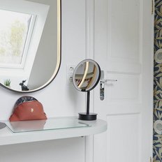 Der Raum zeigt eine moderne Einrichtung mit floralem Tapetenmuster und einem eleganten Waschbecken aus Holz.