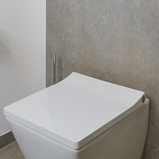 Ein modernes Badezimmer mit einer eleganten weißen Toilette und einem minimalistischen grauen Wanddesign im Hintergrund.