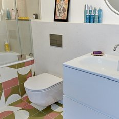 Ein modernes Badezimmer mit einer Badewanne, einer Dusche und bunten, geometrischen Fliesen, die einen frischen Look verleihen.