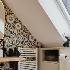 Der Raum zeigt eine elegante Kombination aus Holzregal, Pflanzen und einem schwarzen Hasen, der auf einem weißen Schrank sitzt.