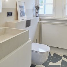Ein modernes Badezimmer mit einem eleganten Waschbecken aus Beton und einem stilvollen schwarzen Wasserhahn.