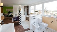 Ein modernes Badezimmer mit großen Fenstern, das viel Tageslicht hereinlässt und eine entspannende Atmosphäre schafft.