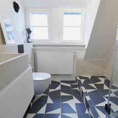 Helles Badezimmer mit großen Fenstern, einem minimalistischen Waschbecken und einer modernen Dusche aus Glas.
