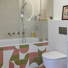 Das Badezimmer zeigt eine stilvolle Badewanne, einen eleganten Waschbeckenunterschrank und dekorative Pflegeprodukte auf dem Regal.