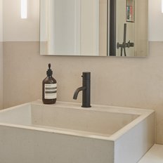 Der Raum zeigt eine stilvolle Waschgelegenheit mit einem großen Spiegel und einer dekorativen Flasche auf der Ablage.