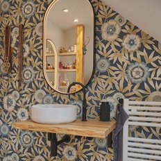 Ein modernes Badezimmer mit einer ovalen Spiegelfläche und einer eleganten Holzablage über einem weißen Waschbecken.