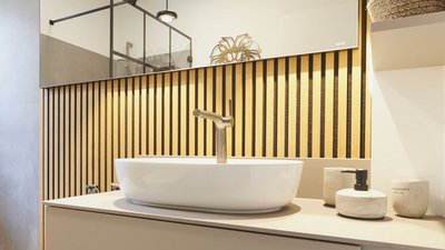 Ein modernes Badezimmer mit einem eleganten, weißen Waschbecken und einem stilvollen Wasserhahn vor einer Holzvertäfelung.