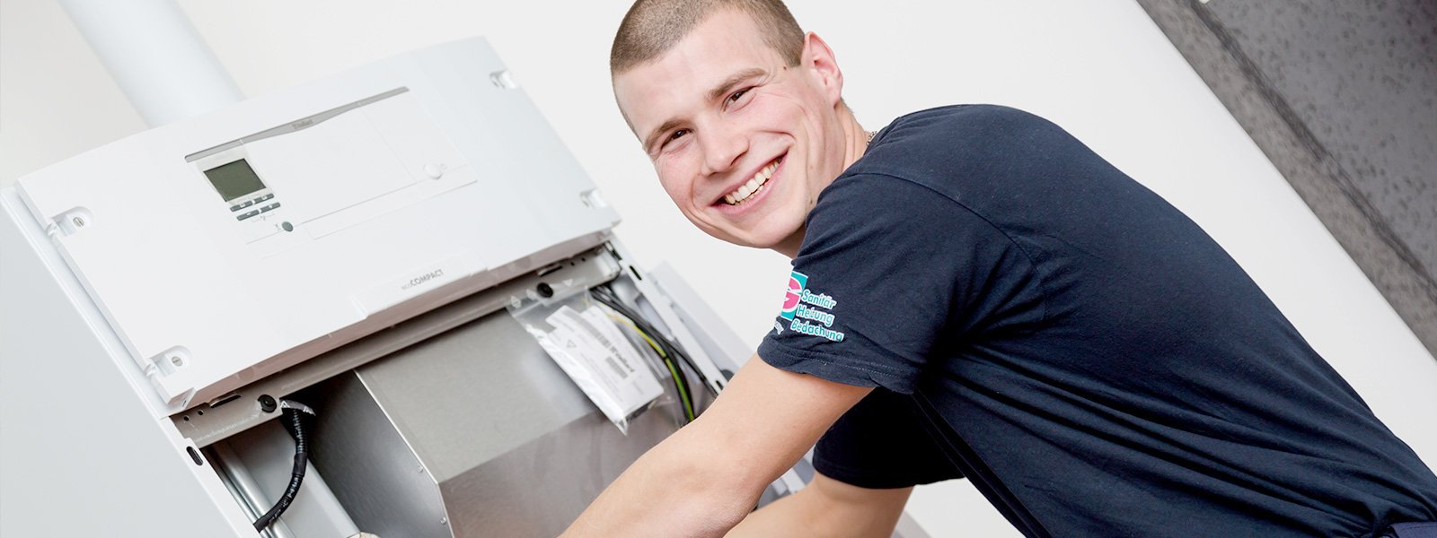 Der Techniker zeigt ein breites Lächeln, während er eine Maschine überprüft, die in einem hellen Raum installiert ist.