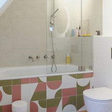 Das Badezimmer zeigt eine stilvolle Badewanne, eine Dusche und eine helle, minimalistische Einrichtung mit dekorativen Elementen.